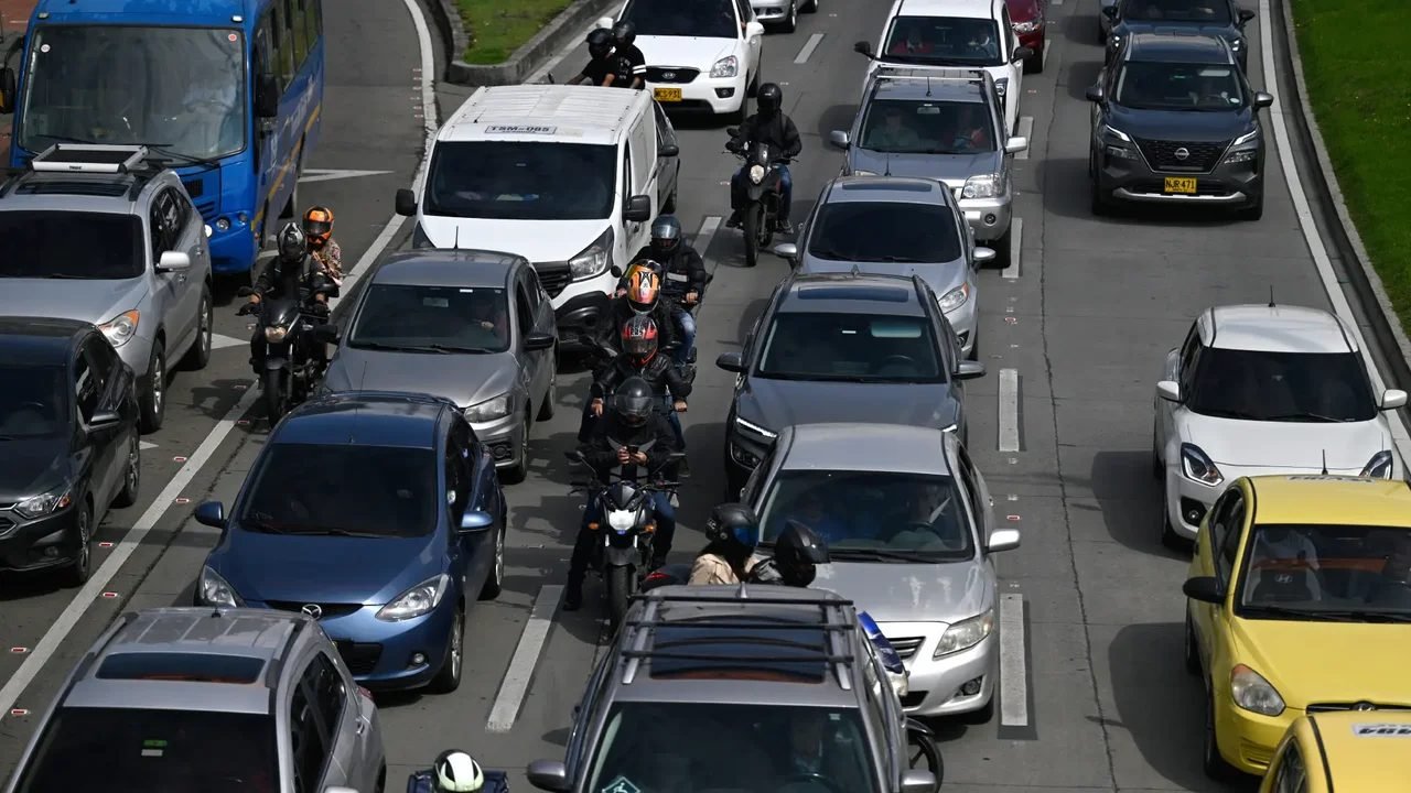 Carros y motos en un trancón en una avenida de Bogotá
